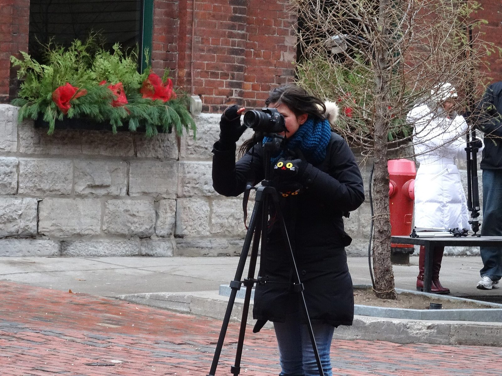 A photographer on the cobblestone streets of Toronto’s Distillery District at Christmas